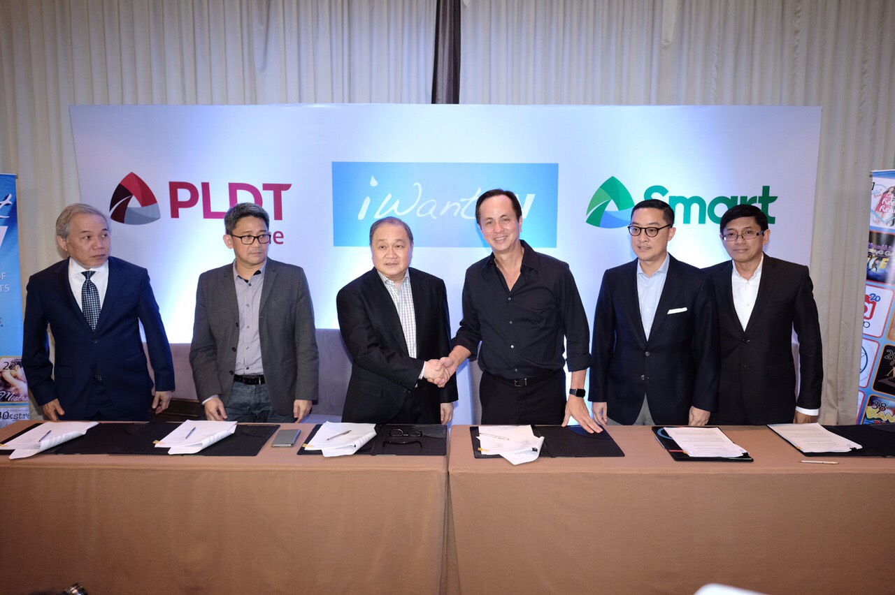 PLDT and Smart Chair Manny V. Pangilinan and Eugenio Gabby Lopez III lead signing of the milestone partnership of PLDT Home and Smart Communications with ABS-CBN for iWant TV. Joining them are Ariel P. Fermin, EVP and Head of Consumer Business for PLDT and Smart; Oscar ‘Renren’ Reyes, FVP and Head of Home Business for PLDT; Katrina Luna-Abelarde, FVP and Head of Smart Wireless Consumer Division; Gary Dujali, VP and Head of PLDT Home Marketing;  Kathy Carag, VP and Head of Smart and Sun Brand; Carlo Katigbak,  ABS-CBN President & CEO ; Aldrin Cerrado, ABS-CBN CFO; Rolando Valdueza, ABS-CBN Group CFO; Cat Lopez, ABS-CBN Head Finance for Broadcast; and Mellissa Limcaoco, ABS-CBN Head of Digital Transformation