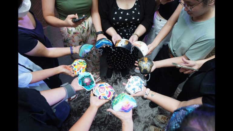 Artists holding their painted LG Puricare Masks during BGC Art Mart